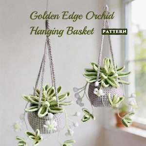 May include: Two hanging crochet baskets with green and white plants. The baskets are gray and suspended by gray cords. The text "Golden Edge Orchid Hanging Basket PATTERN" is visible.