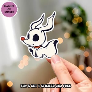 May include: A die-cut sticker or magnet featuring a cartoon ghost dog with a cream-colored body, large black eyes, and a small red nose. The character wears a red collar and has long, pointed ears. Text in the image reads: MAGNET OR STICKER and BUY 5 GET 1 STICKER 2X2 FREE.