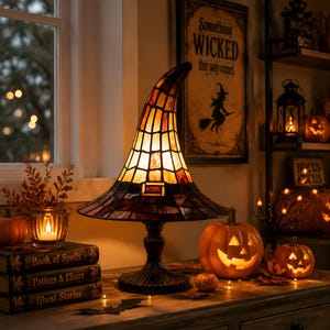 May include: A stained glass table lamp shaped like a pointed witch hat with amber, orange, and dark brown glass panels. The lamp features a dark metal base and a decorative band detail. It emits a warm glow, illuminating the surrounding space.