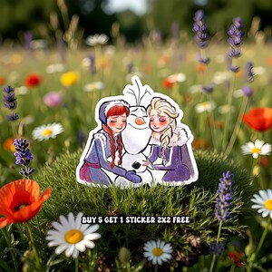May include: A sticker featuring Anna, Elsa, and Olaf from Frozen, hugging each other. The characters are in winter outfits with purple and blue accents. The sticker is set against a backdrop of a field of flowers. Text at the bottom reads: BUY 5 GET 1 STICKER 2X2 FREE.