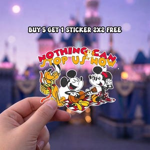 May include: A colorful sticker featuring Mickey Mouse, Minnie Mouse, and Pluto enjoying a picnic. The sticker has the text "NOTHING CAN STOP US NOW" in a playful font. The background shows a castle.