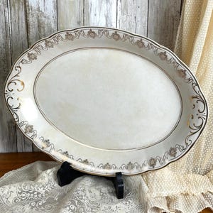 May include: A white ceramic mug with a black handle and the text "But First, Coffee" in a bold, black font. The mug is set against a blurred background, suggesting a cozy setting.