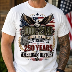 May include: A white t-shirt featuring a graphic of a bald eagle with wings spread over an American flag background. The text reads My DD-214 IS MY CONTRIBUTION TO 250 YEARS OF AMERICAN HISTORY 1776-2026. Two silver dog tags hang from the eagle graphic.