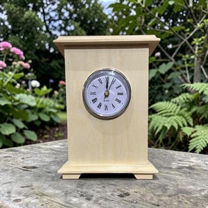 Könnte beinhalten: Ein Set aus drei Keramikbechern mit gesprenkelter, matter Oberfläche. Die Becher sind in Creme-, Hellgrau- und Dunkelgrautönen gehalten. Jeder Becher hat ein schlichtes, minimalistisches Design und einen abgerundeten Henkel.