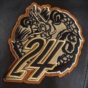 May include: Embroidered patch featuring a dragon design with the number 24. The patch has a black and gold color scheme with a brown border. The dragon is intricately detailed, and the number is outlined in gold.