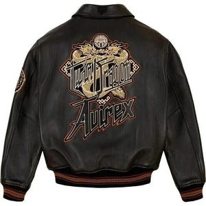 May include: Black leather jacket with a classic collar and a ribbed hem. The back features a gold and black embroidered design with the words "Twin Dragon" and "Avirex". The jacket has a patch on the left sleeve.