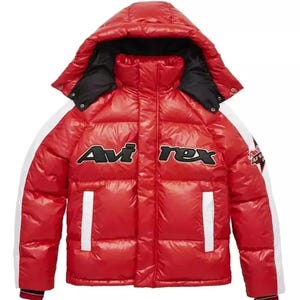 May include: A red puffer jacket with a hood and the text "Avi Rex" across the chest. The jacket has white stripes down the sleeves and white vertical stripes on the front. The hood is lined with black fabric.