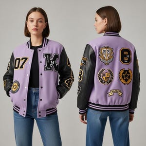May include: A lilac varsity jacket with black leather sleeves. The jacket has patches with the number "07", the letter "K", and other emblems. The back of the jacket features multiple patches with crests and the number "8".