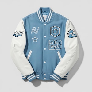 May include: A light blue varsity jacket with white sleeves. The jacket features the letters "AV", a star, and the number "23" on the front. Patches with wave designs are on the sleeves. The jacket has a button-up closure and striped cuffs and collar.