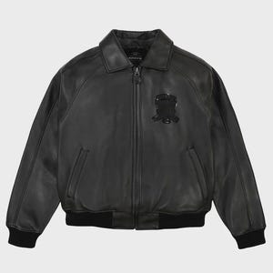 May include: Black leather jacket with a zip-up front, collar, and a black emblem on the chest. The jacket has two front pockets and black ribbed cuffs and hem. The brand name "AVIREX" is visible on the collar.