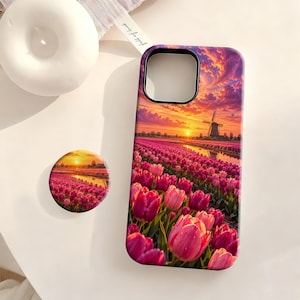 May include: A rectangular phone case and a circular phone grip featuring a vibrant sunset landscape with a field of pink tulips and a traditional windmill. The scene displays a bright orange and purple sky reflecting over a canal.