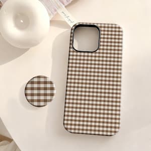 May include: A brown and white gingham patterned phone case and matching phone grip. The phone case has a black camera cutout. The phone grip is round and has the same pattern as the phone case. The items are on a white surface.