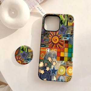 May include: A colorful phone case and matching pop socket featuring a collage design with suns, moons, stars, and geometric shapes. The case has a black border and a cutout for the camera. The pop socket has a blue star.