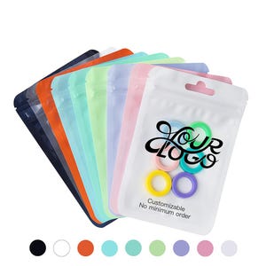 May include: A selection of colourful, resealable plastic pouches in various shades, including black, orange, and pink. The front pouch displays the text "Your Logo" and "Customizable No minimum order" with colourful rings.