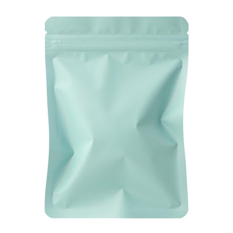 May include: A light teal-colored, stand-up pouch with a zip-top closure. The bag is empty and has several creases, giving it a textured appearance. The pouch is designed for packaging and storage.