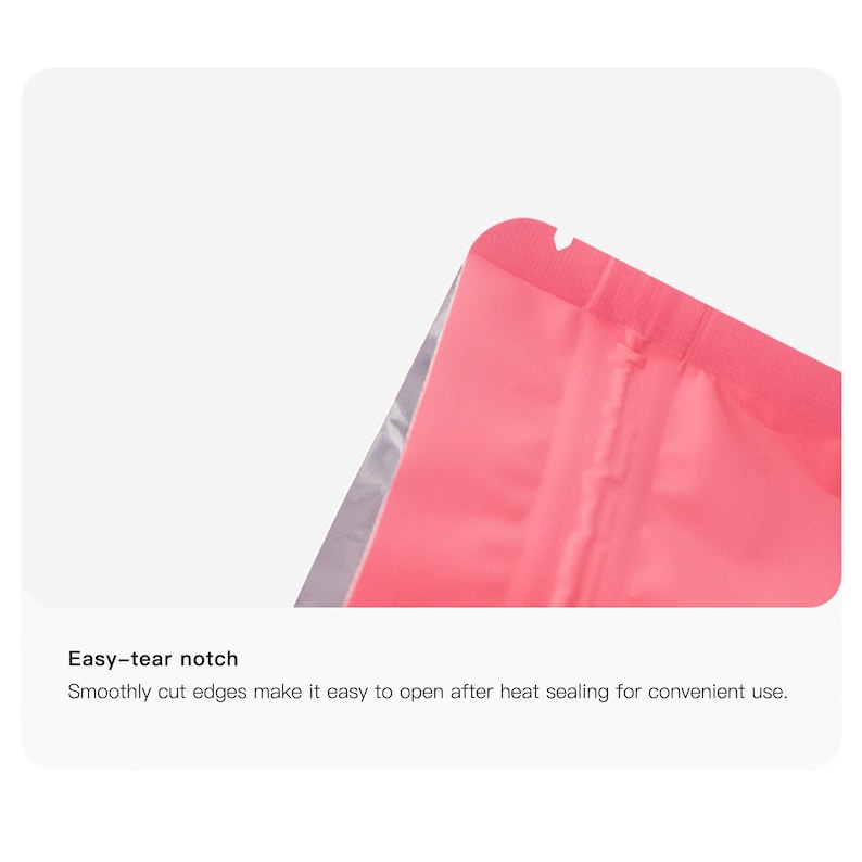 May include: Close-up of a pink, heat-sealable pouch with an easy-tear notch. The edges are smoothly cut for easy opening after sealing. The pouch has a silver interior.