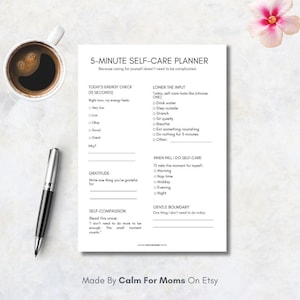 May include: A white 5-Minute Self-Care Planner with sections for energy checks, gratitude, and self-compassion. Includes a pen, a cup of coffee, and a flower. The planner is designed to simplify self-care routines.