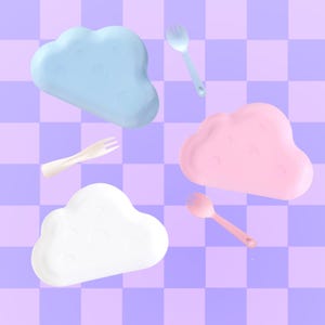 May include: Four cloud-shaped plates in blue, pink, and white, with matching forks and spoons. The plates and utensils are arranged on a checkered purple and lavender background. The design is whimsical and playful.