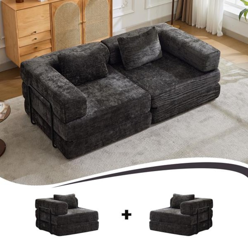 May include: A dark grey modular sofa featuring a textured corduroy fabric, two square back cushions, and a black metal frame on the sides. The sofa is composed of two separate armless chair sections placed together to form a single seating unit.