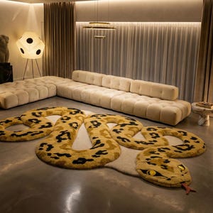 Op de afbeelding: Een moderne woonkamer met een grote, crèmekleurige hoekbank en een uniek slangvormig tapijt met gele en zwarte vlekken. De kamer wordt verlicht door diverse lampen en heeft een neutraal kleurenpalet.