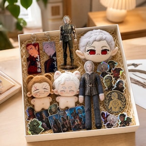 May include: A gift box containing various character-themed merchandise, including two plush dolls with animal ears, a plush head, a standing acrylic figure, a fabric doll, several acrylic keychains, holographic stickers, and a circular metal coin.