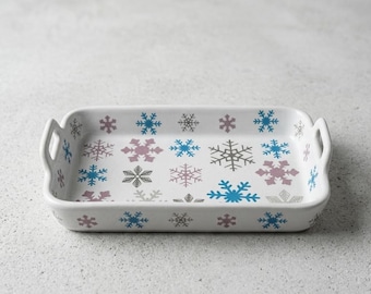 Teglia da forno con fiocchi di neve invernali, decorazione festiva in ceramica per la cucina durante le vacanze.