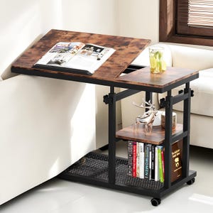 May include: A brown and black adjustable side table with a tilting tabletop, a lower shelf, and a mesh base. The table has a metal frame and sits on wheels. A book and a glass of water are on the table.