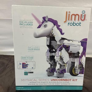 Puede incluir: Una caja blanca con un kit de juguete de unicornio robótico. El kit incluye una bocina LED RGB programable y un sensor de color. El texto en la caja dice "Jimu robot" y "Mythical Series: Unicornbot Kit". Para mayores de 8 años.
