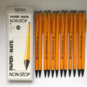 May include: A box of Paper Mate Non-Stop HB pencils with a dozen yellow pencils. The box is white with black text and a graphic of a pencil. The pencils are yellow with black tips and silver clips.