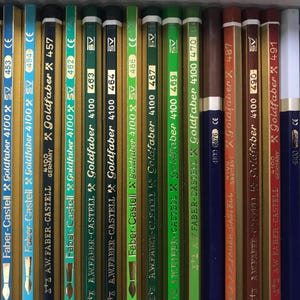 K&ouml;nnte beinhalten: Eine Sammlung von Goldfaber 4100 Bleistiften von Faber-Castell, vertikal angeordnet. Die Bleistifte sind in verschiedenen Farben erh&auml;ltlich, darunter Blau, Gr&uuml;n, Braun und Gold. Jeder Bleistift hat eine Nummer und das Faber-Castell-Logo.