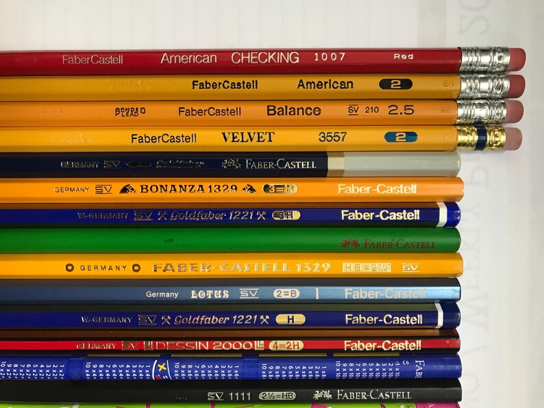 May include: A white ceramic mug with a black handle and the text "But First, Coffee" in a bold, black font. The mug is set against a blurred background, suggesting a cozy setting. The mug appears to be approximately 4 inches tall.