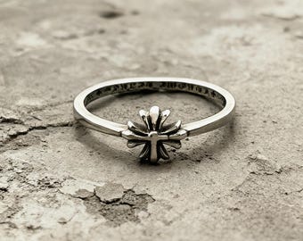 Anillo apilable con diseño de cruz pequeña y flor, banda gótica fina de plata y oro envejecidos.