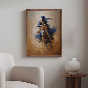 May include: A framed artwork showing a figure on horseback, painted in a painterly style. The rider, in blue and gold, holds a sword. The background has warm, earthy tones, with blue splashes. The artwork is displayed in a room with a neutral colour palette.