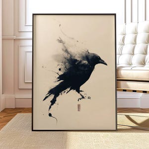 以下が含まれることがあります： 水彩効果のある黒いカラスを描いた額入りのアートプリント。鳥は横顔で描かれ、詳細な暗い羽と鋭いくちばしがあります。アートワークはミニマリストスタイルで、ニュートラルな背景と小さな赤いスタンプが付いています。