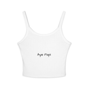 May include: White crop top with thin straps. The text "Aye Papi" is printed in black, centered on the front of the top. The top is made of a ribbed fabric.