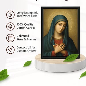 May include: A framed canvas print featuring a religious portrait of a woman in a blue veil. The artwork is displayed on a white pedestal with green leaves. Text on the left reads "Ready to Hang", "Long-lasting Ink", "100% Quality Cotton Canvas", and "Unlimited Sizes & Frames."