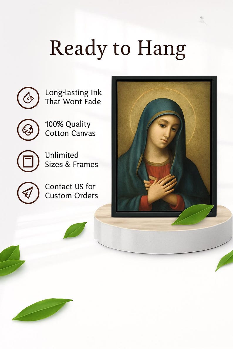 May include: A framed canvas print featuring a religious portrait of a woman in a blue veil. The artwork is displayed on a white pedestal with green leaves. Text on the left reads "Ready to Hang", "Long-lasting Ink", "100% Quality Cotton Canvas", and "Unlimited Sizes & Frames."
