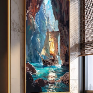 Könnte beinhalten: Ein gerahmter Leinwanddruck zeigt ein großes Schiff, das durch eine Meereshöhle segelt. Das Kunstwerk weist eine warme Farbpalette auf, wobei die Segel des Schiffes vom Sonnenlicht beleuchtet werden. Das Wasser ist ein leuchtendes Türkis, die Höhlenwände sind braun und orange.