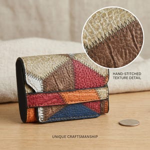 Puede incluir: Una pequeña cartera de cuero multicolor con un diseño de patchwork. La cartera presenta una variedad de colores, incluyendo rojo, naranja, azul y marrón. El texto "HAND-STITCHED TEXTURE DETAIL" y "UNIQUE CRAFTSMANSHIP" son visibles.