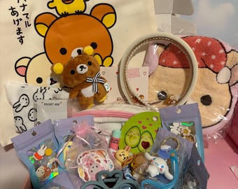 May include: A pink box filled with various Kawaii-themed items. Includes a plush bear, a headband, a towel with a bear design, and several small bags containing charms and accessories. The box also contains a pen and a small backpack.