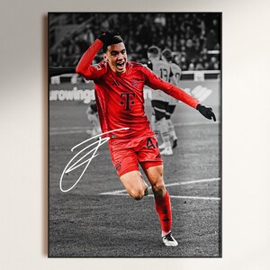 Pode incluir: Impress&atilde;o emoldurada de um jogador de futebol com uniforme vermelho, n&uacute;mero 47, comemorando um gol. O fundo &eacute; em preto e branco. Uma assinatura branca &eacute; vis&iacute;vel na impress&atilde;o.