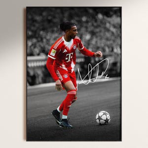 Pode incluir: Impress&atilde;o emoldurada de um jogador de futebol com uniforme vermelho e branco, driblando uma bola de futebol. A assinatura do jogador &eacute; vis&iacute;vel. O fundo &eacute; uma imagem desfocada em preto e branco de uma multid&atilde;o.
