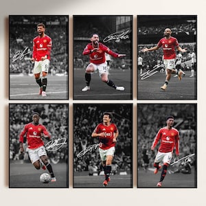 May include: Six framed prints of soccer players in red jerseys, set against a monochrome stadium backdrop. Each print shows a player in action, with their signature. The prints are a mix of action shots and portraits, suitable for a sports fan.