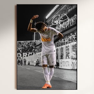 Puede incluir: Impresión enmarcada en blanco y negro de un futbolista con una camiseta blanca con la palabra "Santos" y el número 1. El jugador levanta el brazo en señal de celebración. La imagen incluye una firma.