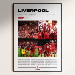 May include: A framed poster featuring the word "LIVERPOOL" at the top, with "LIVERPOOL, ENGLAND SINCE 1892" below. The poster includes images of a soccer team in red uniforms, celebrating with trophies and flags. The team's logo is at the bottom.