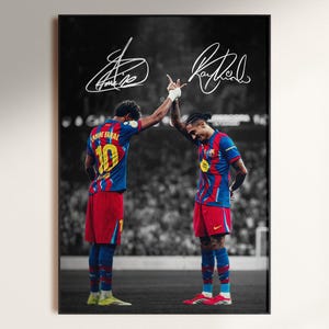 May include: A framed black and white photograph featuring two soccer players in their team uniforms, with signatures at the top. The players are in red, blue, and yellow jerseys and shorts, with the number 10 visible on one player's jersey.