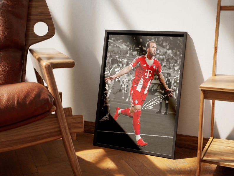 Pode incluir: Fotografia a preto e branco emoldurada de um jogador de futebol com uniforme vermelho e branco, em corrida, com uma assinatura. O jogador &eacute; o ponto focal, contra um fundo desfocado de um est&aacute;dio. A moldura &eacute; retangular.