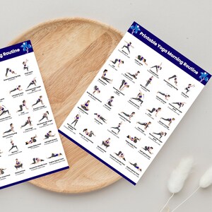 Flat lay view of two printed yoga routine posters neatly placed inside a round wooden tray, showing illustrations of different yoga stretches like Warrior, Child's pose, and Downward dog.