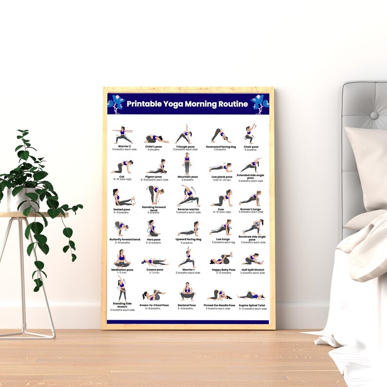 A framed "Printable Yoga Morning Routine" poster displayed as wall art on the floor next to a bed and a green potted plant, showing a clean aesthetic bedroom setup.