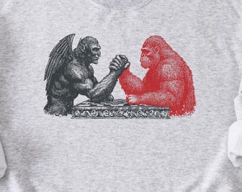 おもしろいビッグフット・モスマンのアームレスリングTシャツ、キャンプやコミコンファンのための未確認生物グラフィックTシャツ